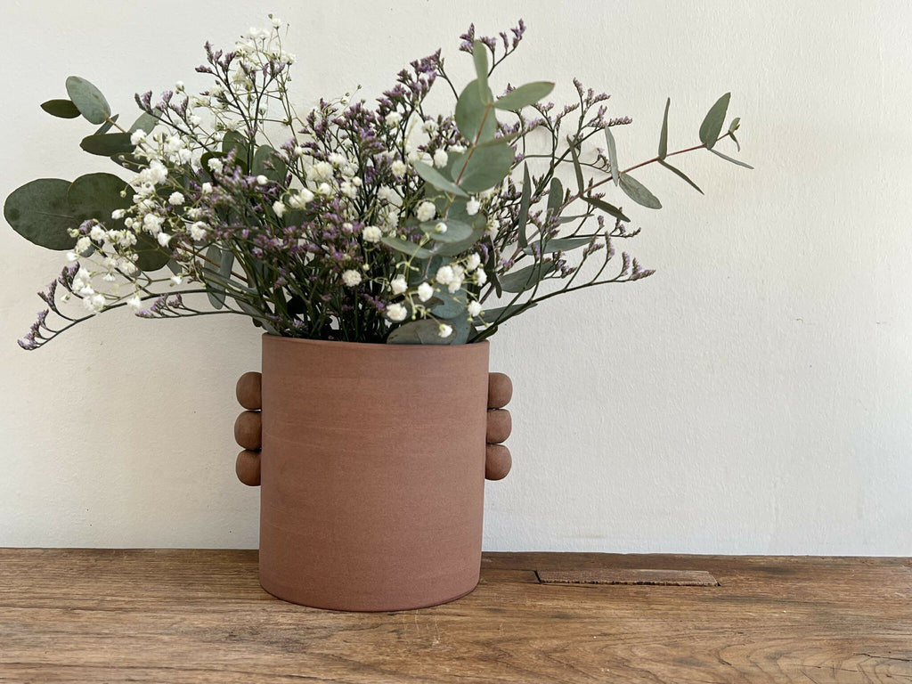 Vase en grès roux PALMA cylindrique, bouquet de fleurs blanches et violettes.