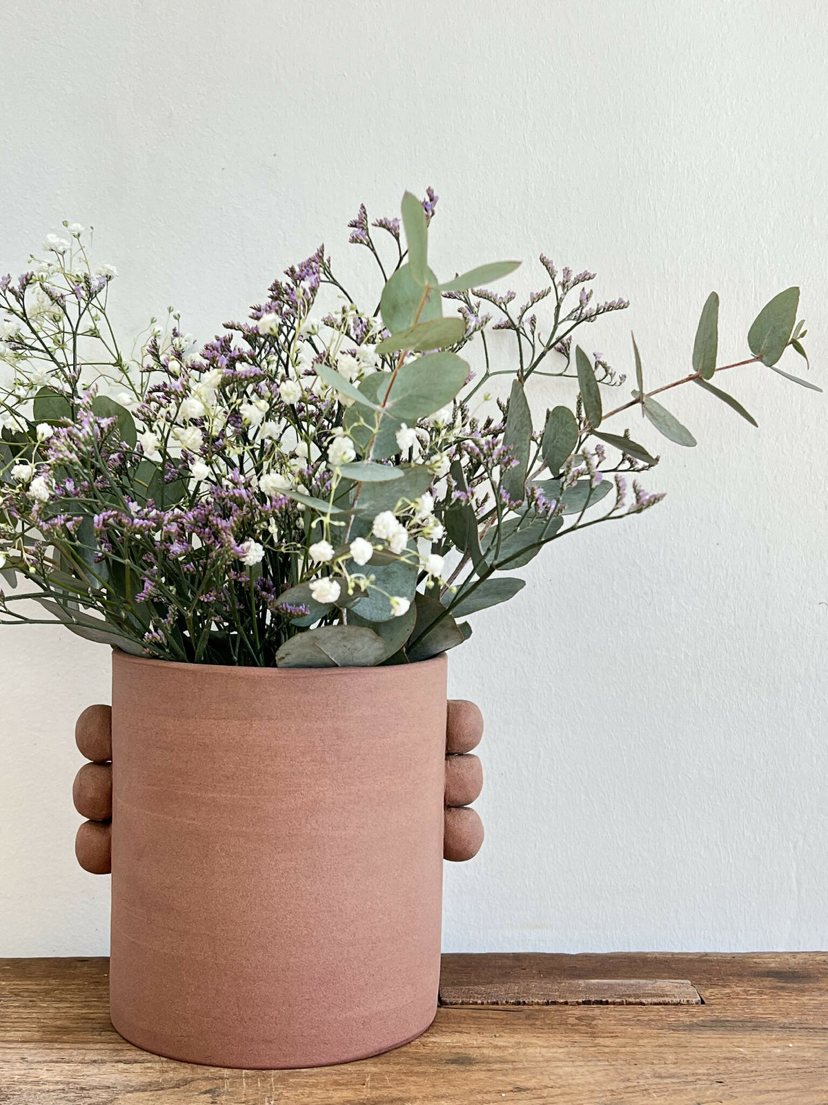 Vase en grès roux PALMA, bouquet pastel de fleurs blanches et mauves avec tiges vertes.