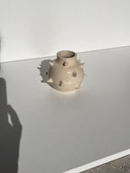 Petit vase en céramique beige à pointes, vue de côté, ouverture en cercle