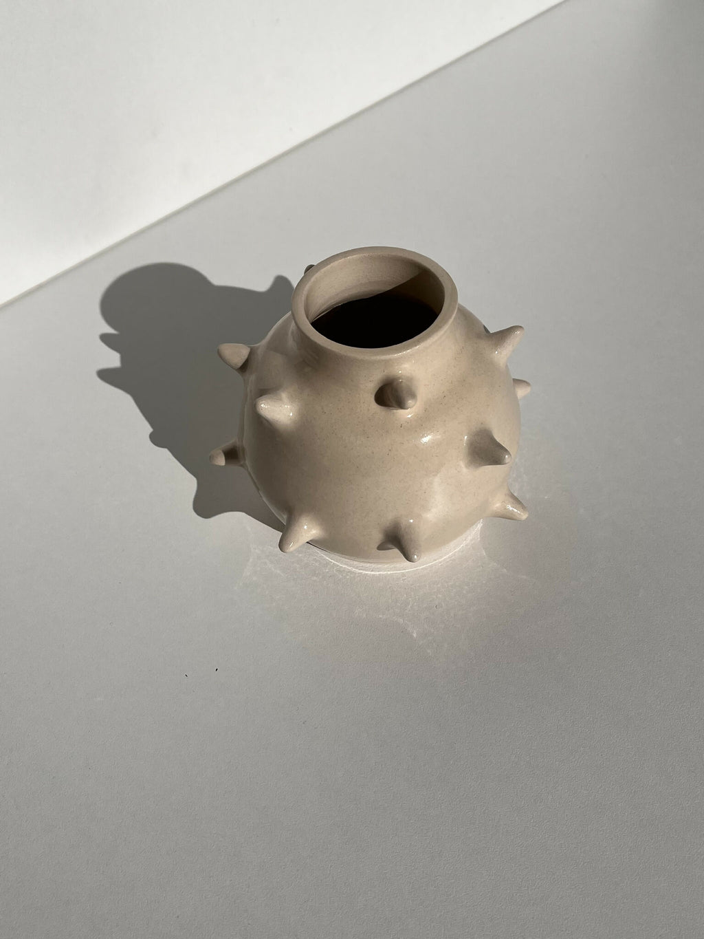 Vase en céramique beige à reliefs en pointes, ouverture circulaire