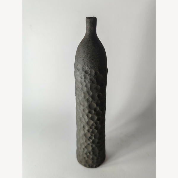 Soliflore sculpté noir en forme de bouteille, finition mate texturée, vue 3/4.