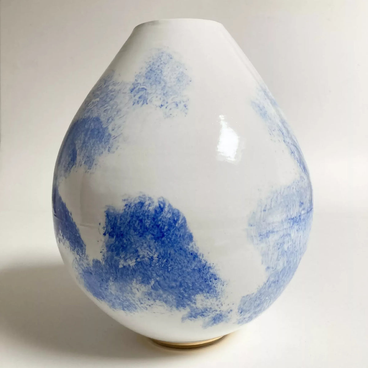Vase en céramique blanc, zones de peinture bleu, finition brillante, forme goutte.