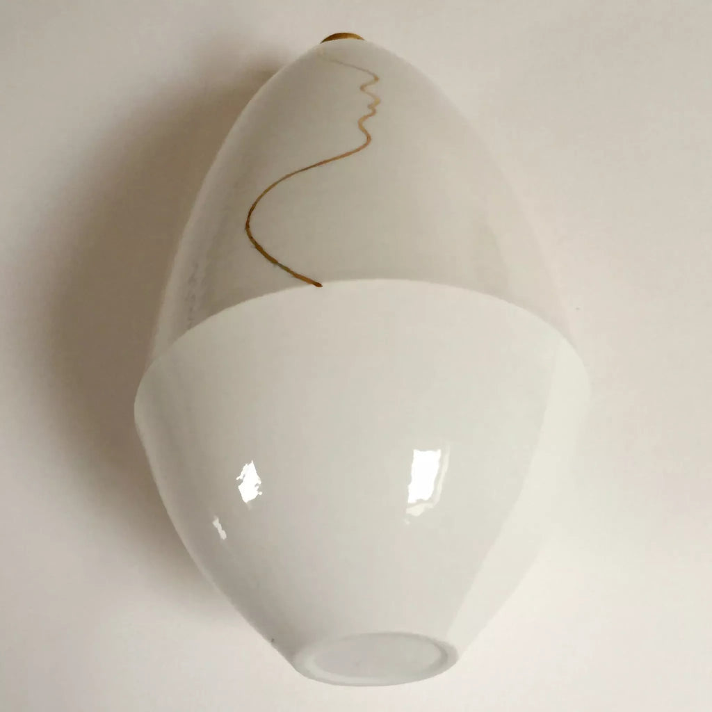 Vase soliflore en céramique blanche, col doré, ligne de visage au trait.