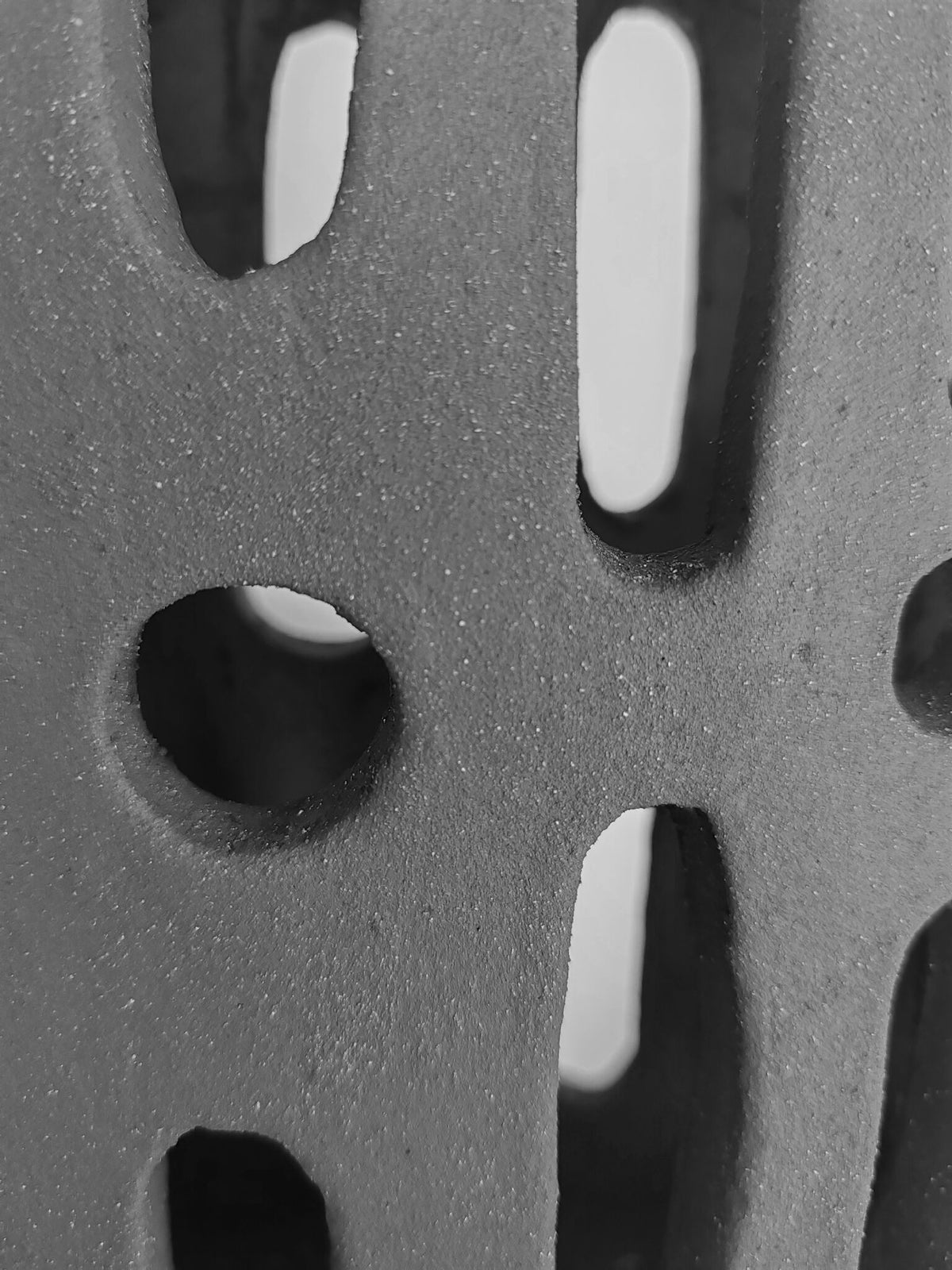Vase en céramique noire, gros plan sur les découpes ovales et allongées