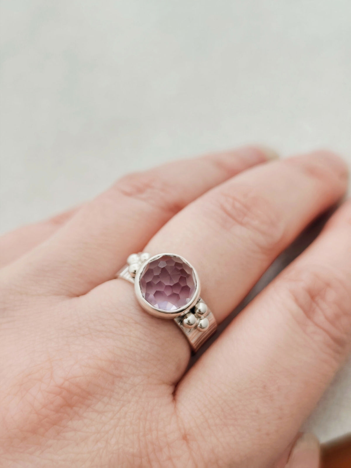 Bague argentée à pierre améthyste violet, anneau ajouré et détails en billes.