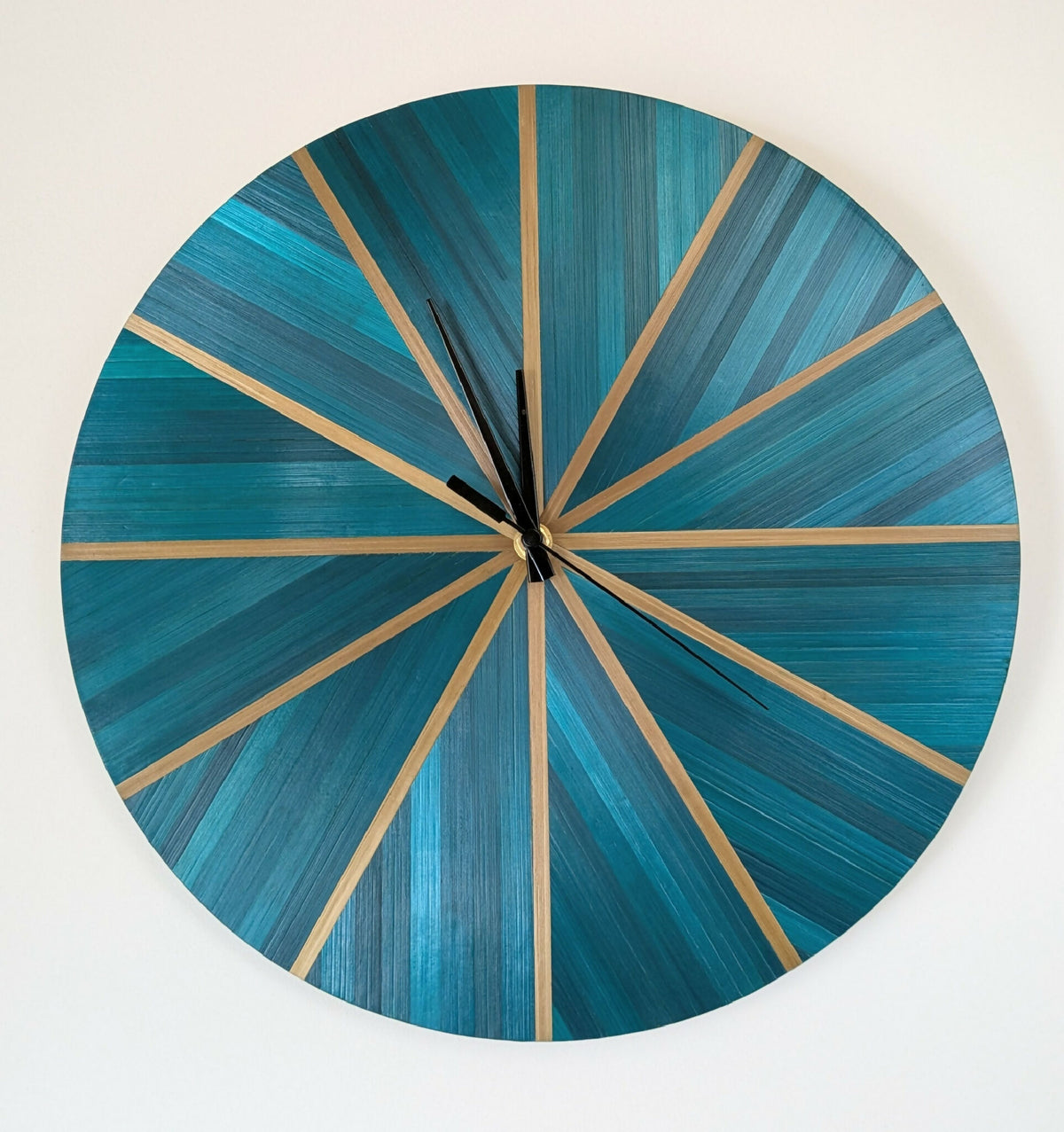 Horloge murale ronde en marqueterie paille bleu-vert et doré, cadran rayé, aiguilles noires