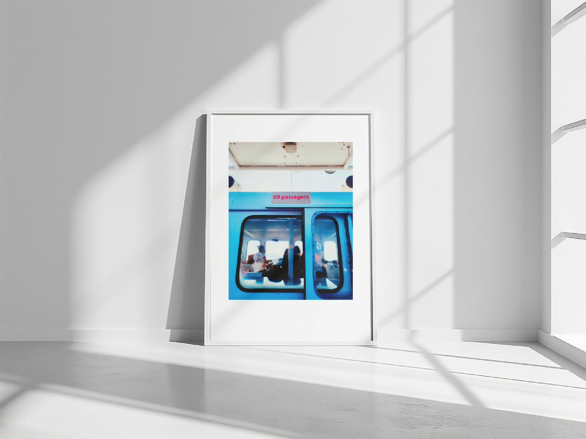 Photo encadrée rectangulaire, sur sol clair, vue intérieure de bus bleu
