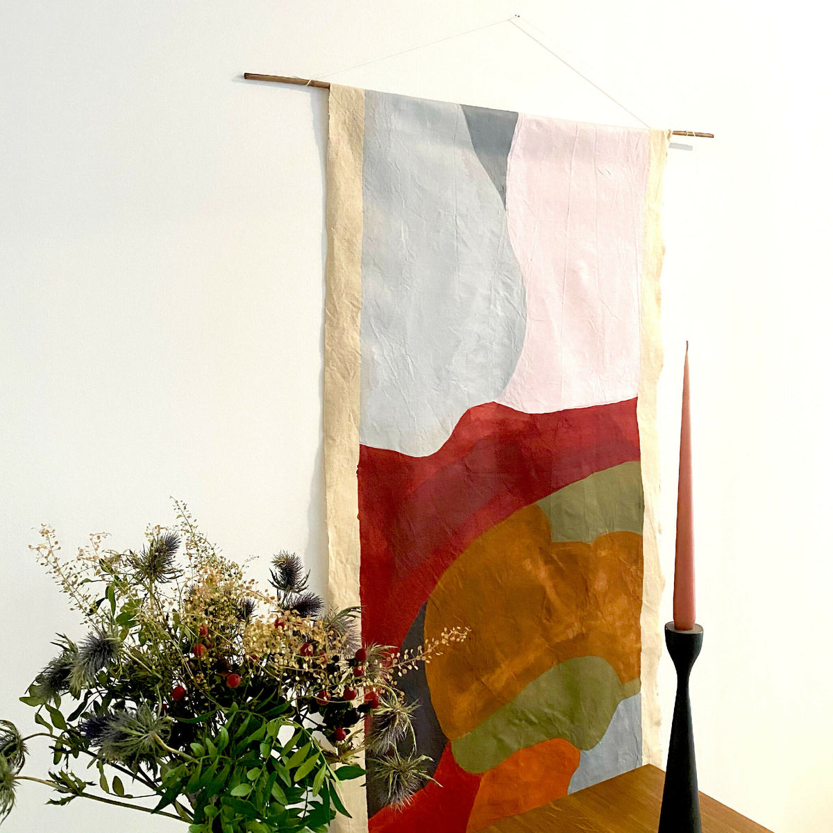 Tenture murale en tissu blanc avec formes abstraites rouge, ocre, gris et rose