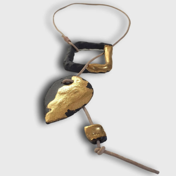 Collier avec pendentif noir et incrustation dorée, cordon brun