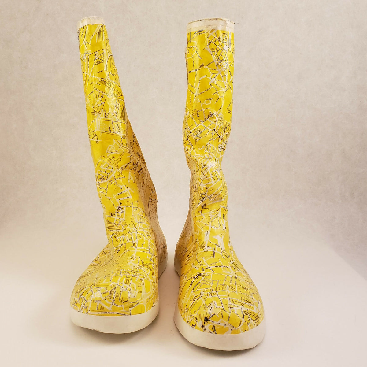 Bottes jaunes tige haute avec motif, vue de face, semelle blanche arrondie.