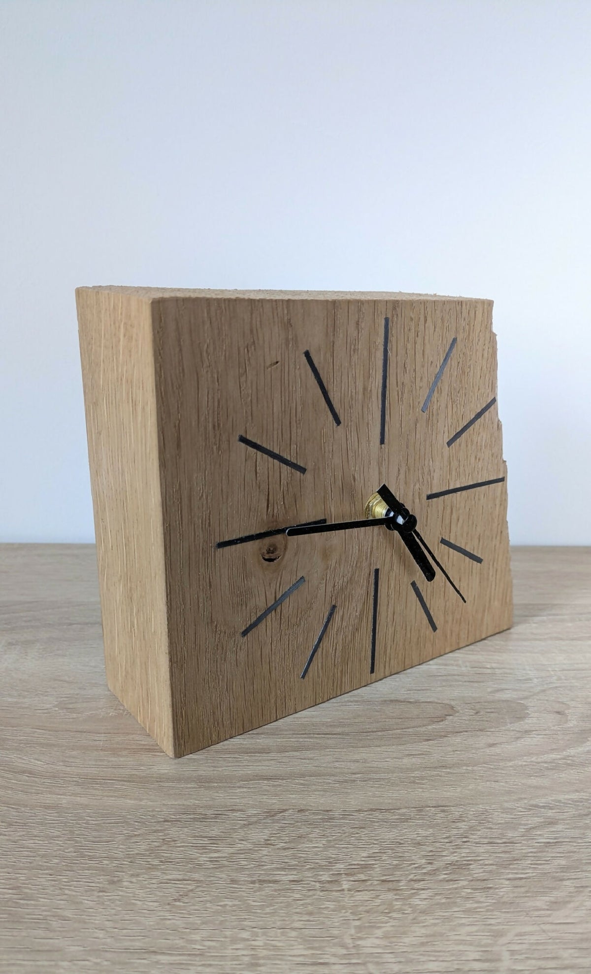 Horloge de bureau en chêne, cadran avec repères noirs et bleutés, aiguilles dorées.