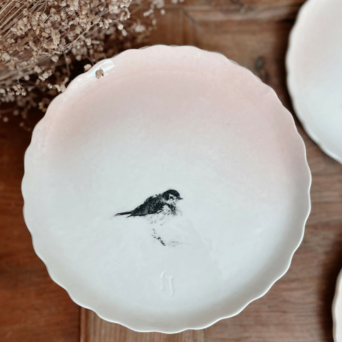 Assiette à dessert en porcelaine blanche, bord festonné, petit oiseau noir au centre