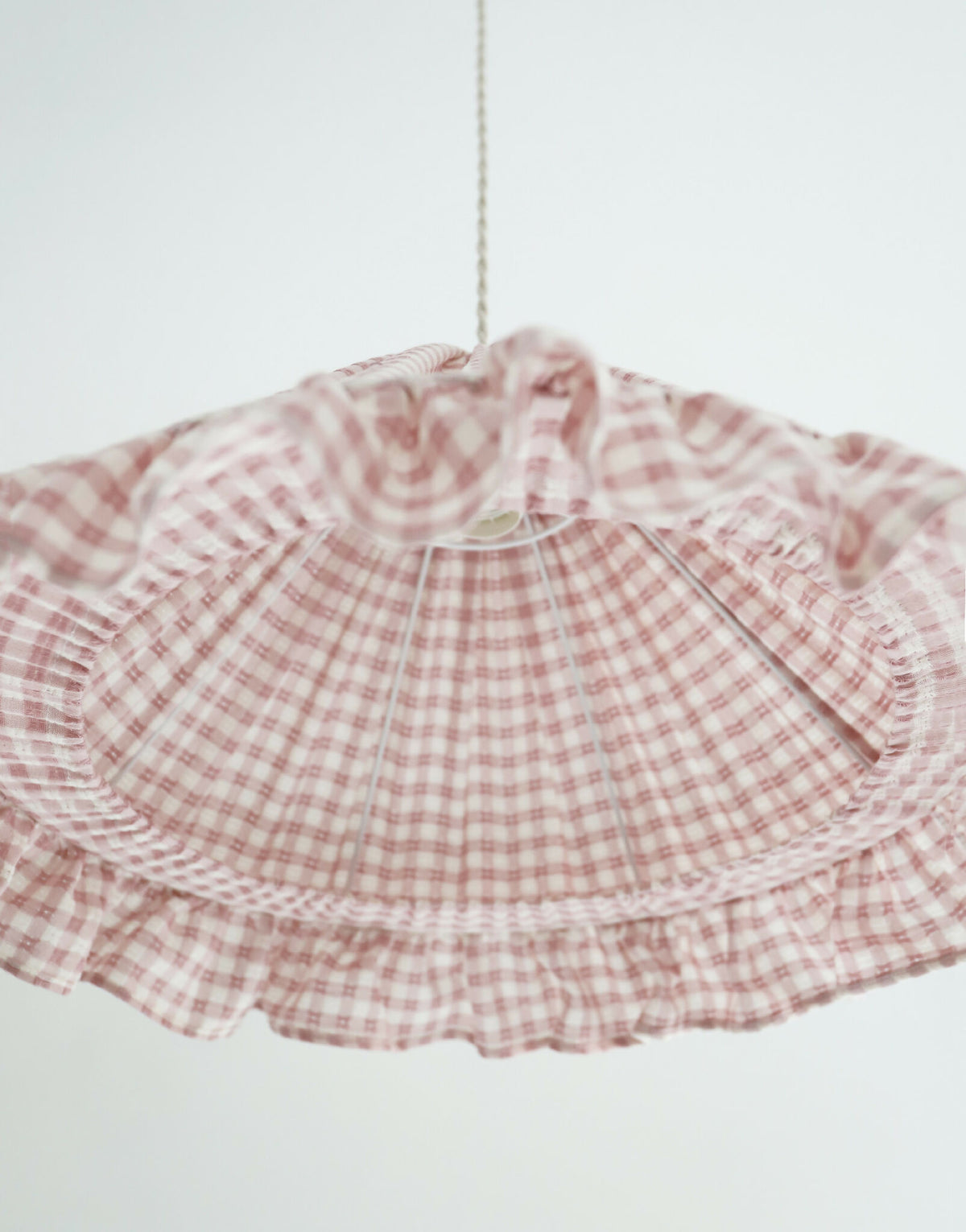 Abat-jour conique en tissu à petits carreaux rose, volants froncés et couture centrale.