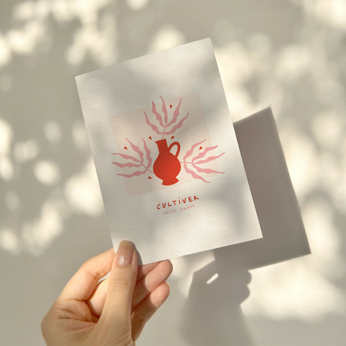 Carte de vœux blanche tenue en main, illustration rouge « Cultiver »