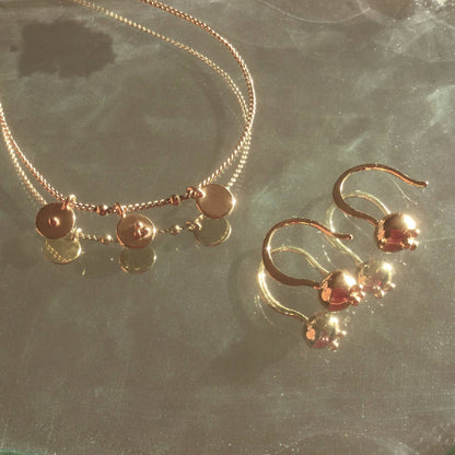 Collier doré à breloques rondes et mini cœurs sur chaîne fine