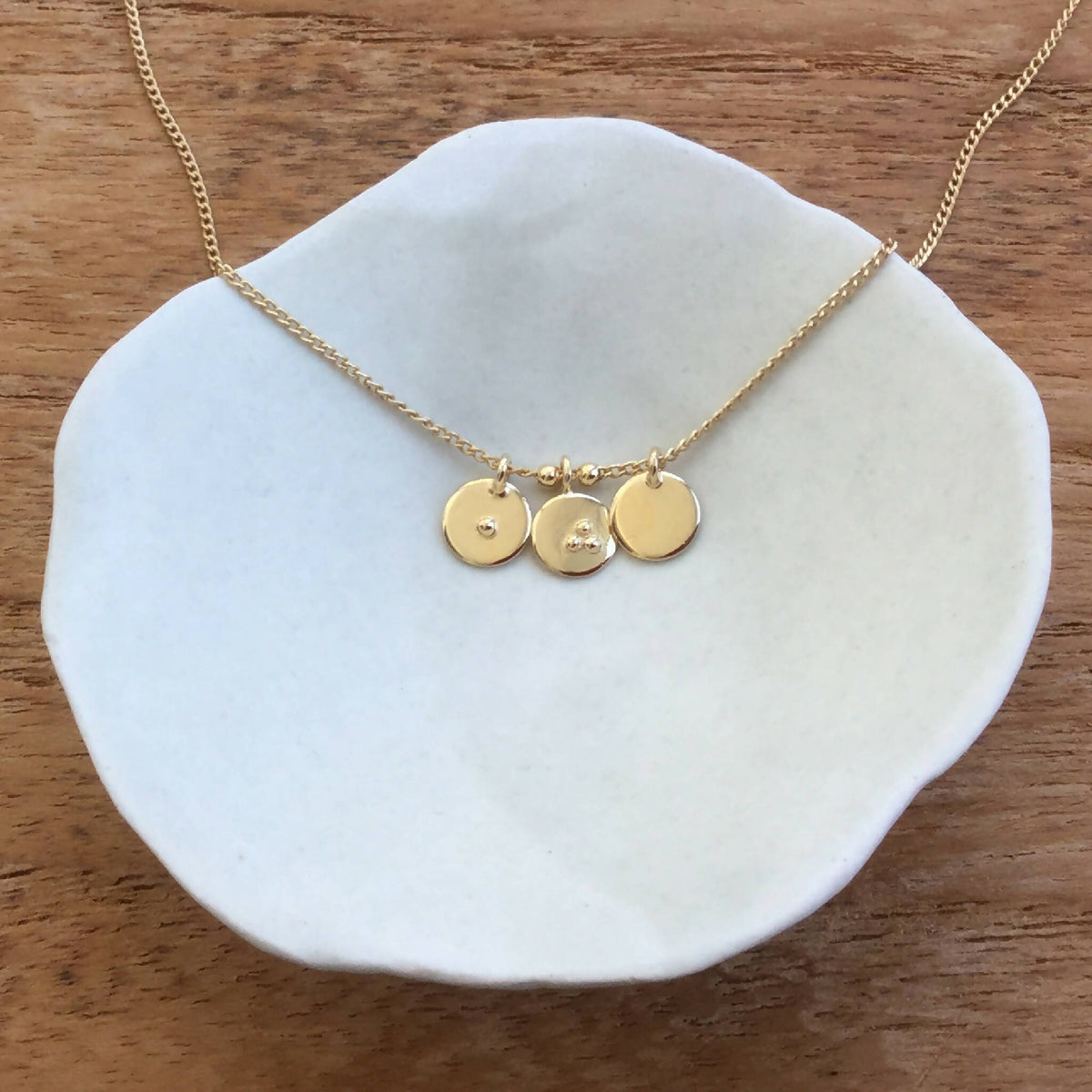 Collier fin doré avec trois breloques rondes gravées