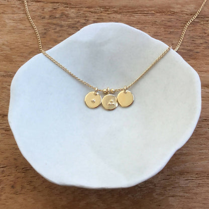 Collier fin doré avec trois breloques rondes gravées