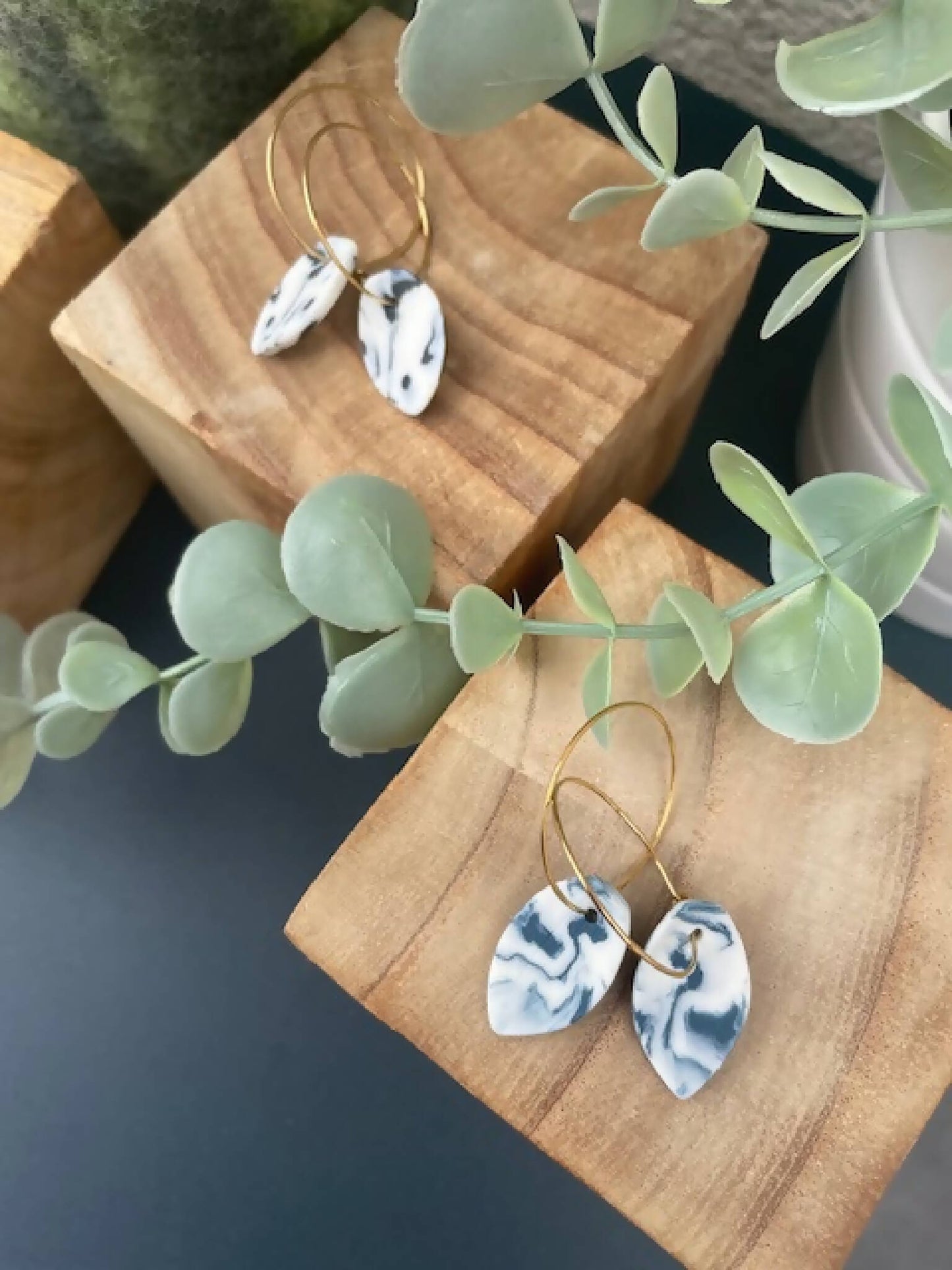 Créoles dorées avec pendentifs goutte bleu marbré, vue rapprochée.