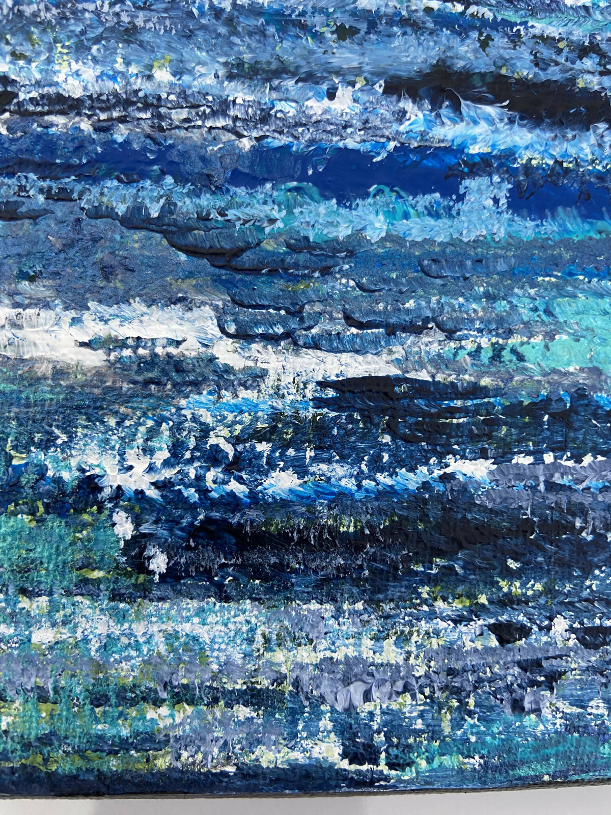 Gros plan peinture abstraite : bandes bleues, blanches et touches turquoise sur toile.