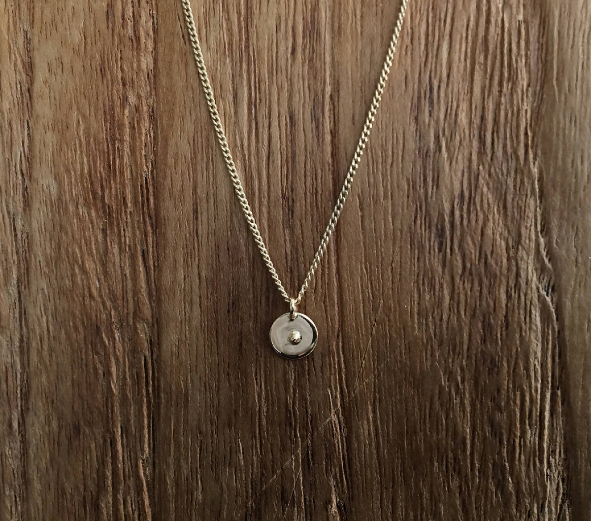 Collier à chaîne dorée et médaillon rond argenté