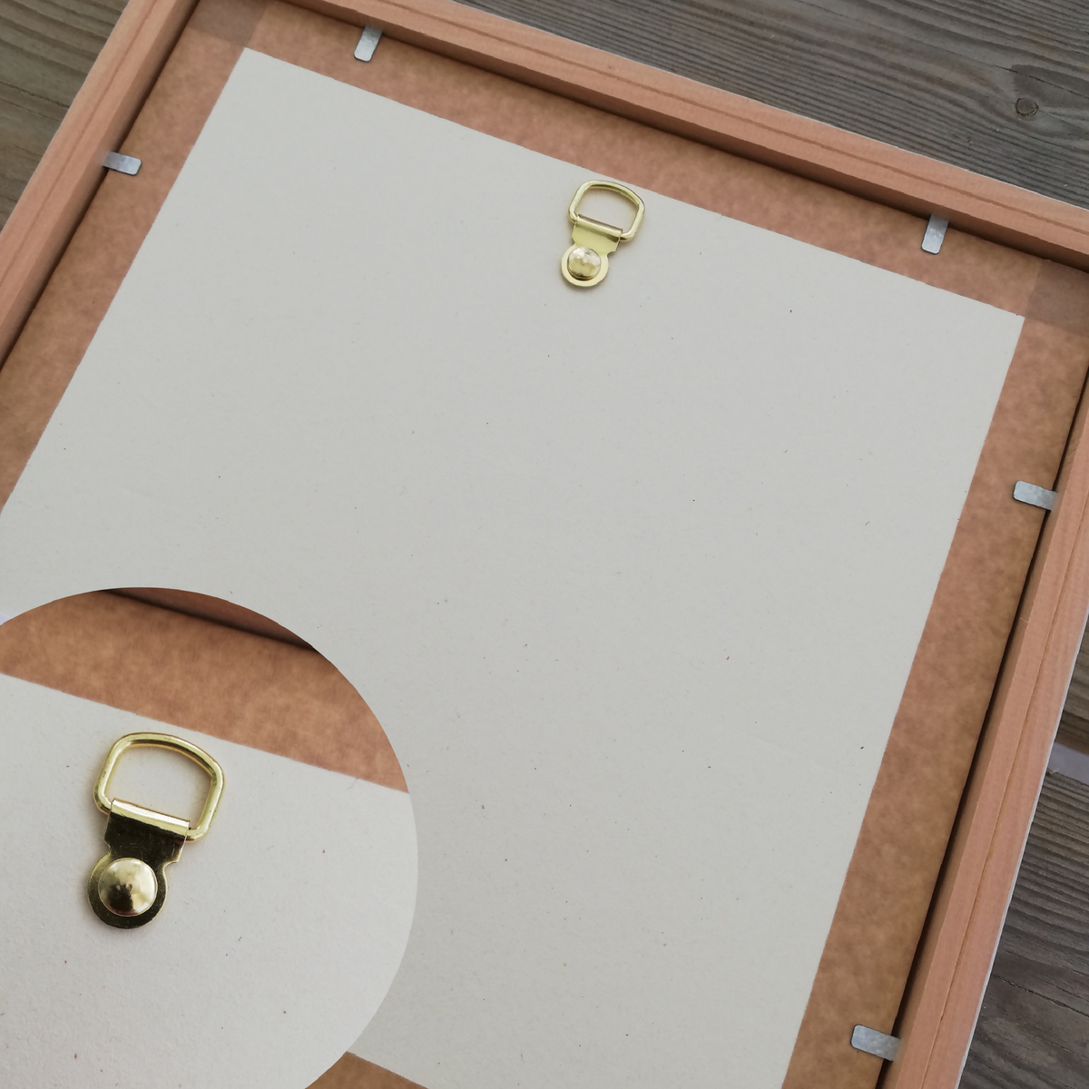 Lampe à poser avec cadre en bois clair au dos, attaches métalliques dorées visibles