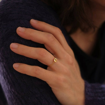 Bague dorée sur doigt, cabochon bleu nuit ovale