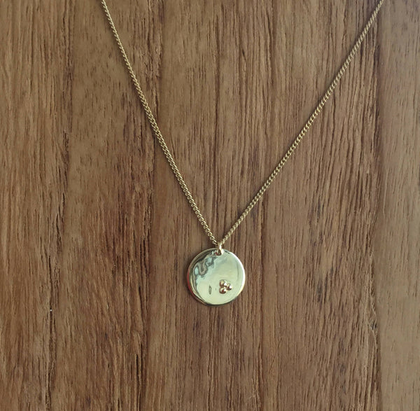 Collier à chaîne dorée et pendentif rond clair avec petit motif gravé