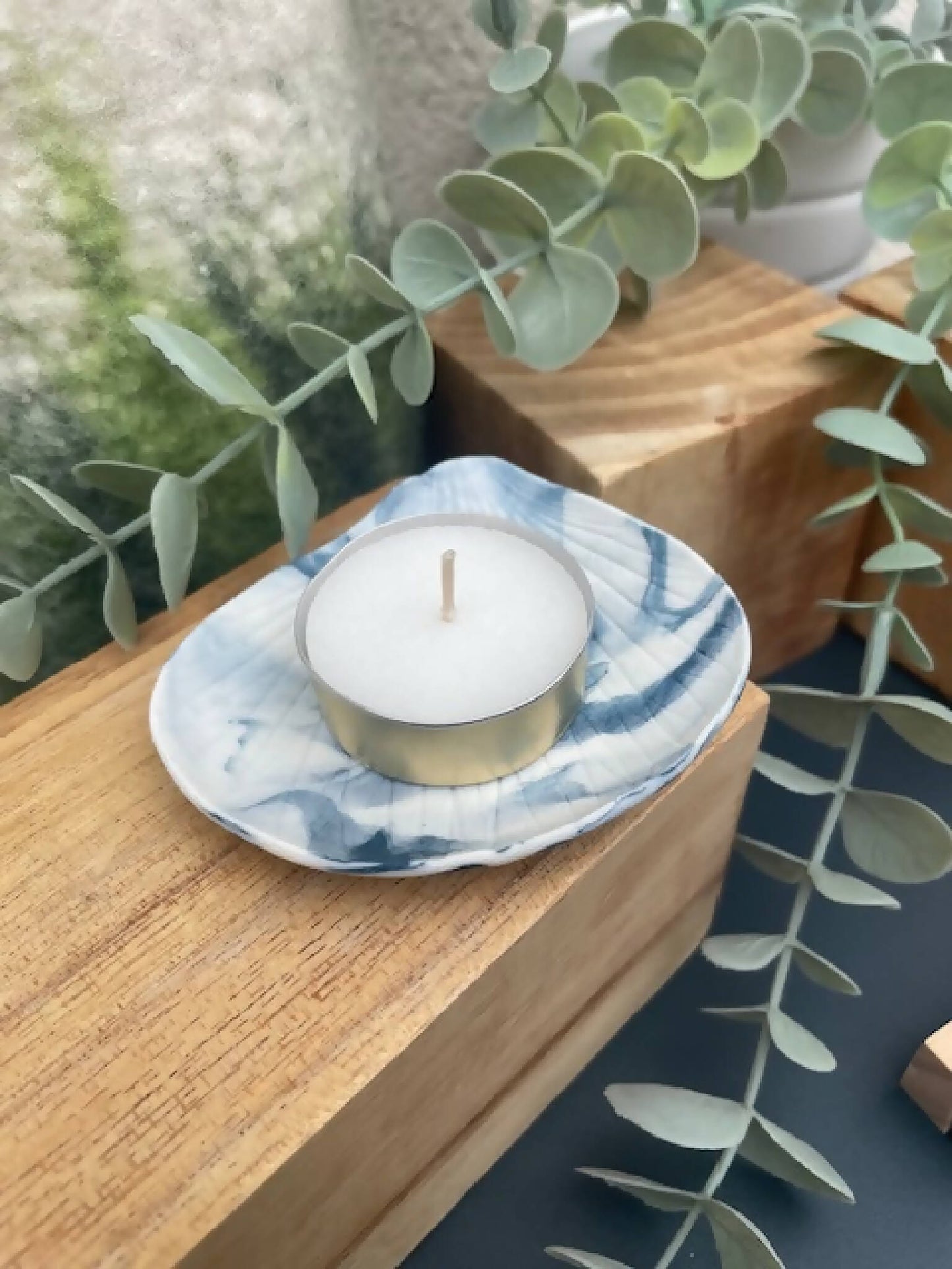 Bougeoir coupelle marbrée bleu en porcelaine, bougie blanche dans base dorée, vue de dessus.