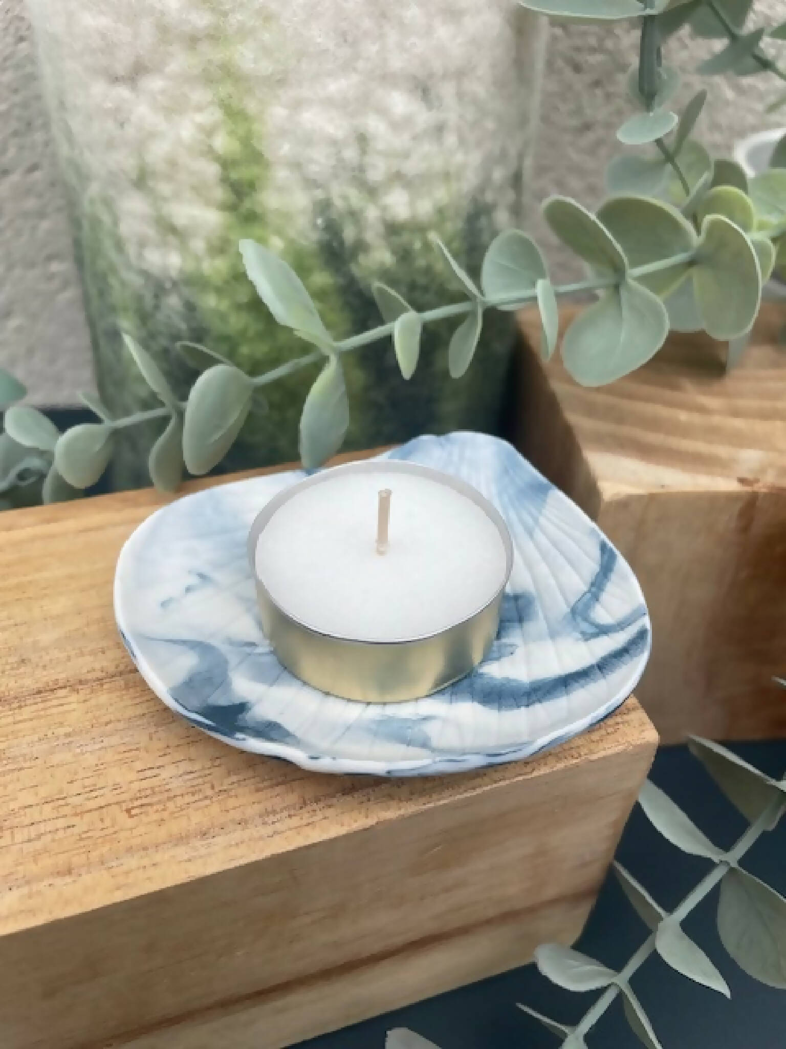 Bougeoir porcelaine marbrée bleu, coupelle ondulée et bougie blanche sur base dorée.