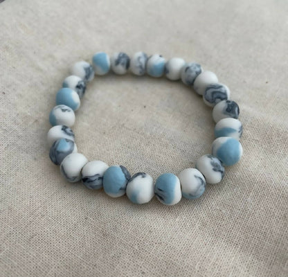 Bracelet femme en perles de porcelaine bleu clair et blanches, motif marbré.