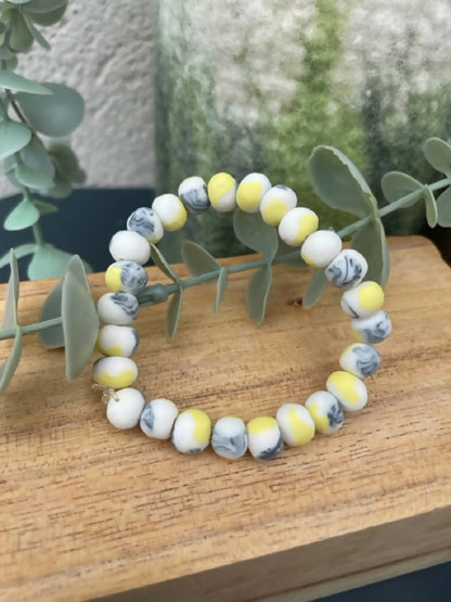 Bracelet femme en perles de porcelaine blanc et jaune avec touches bleu clair.