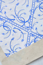 Coin de tissu bleu, losanges à arabesques et bordure cloutée