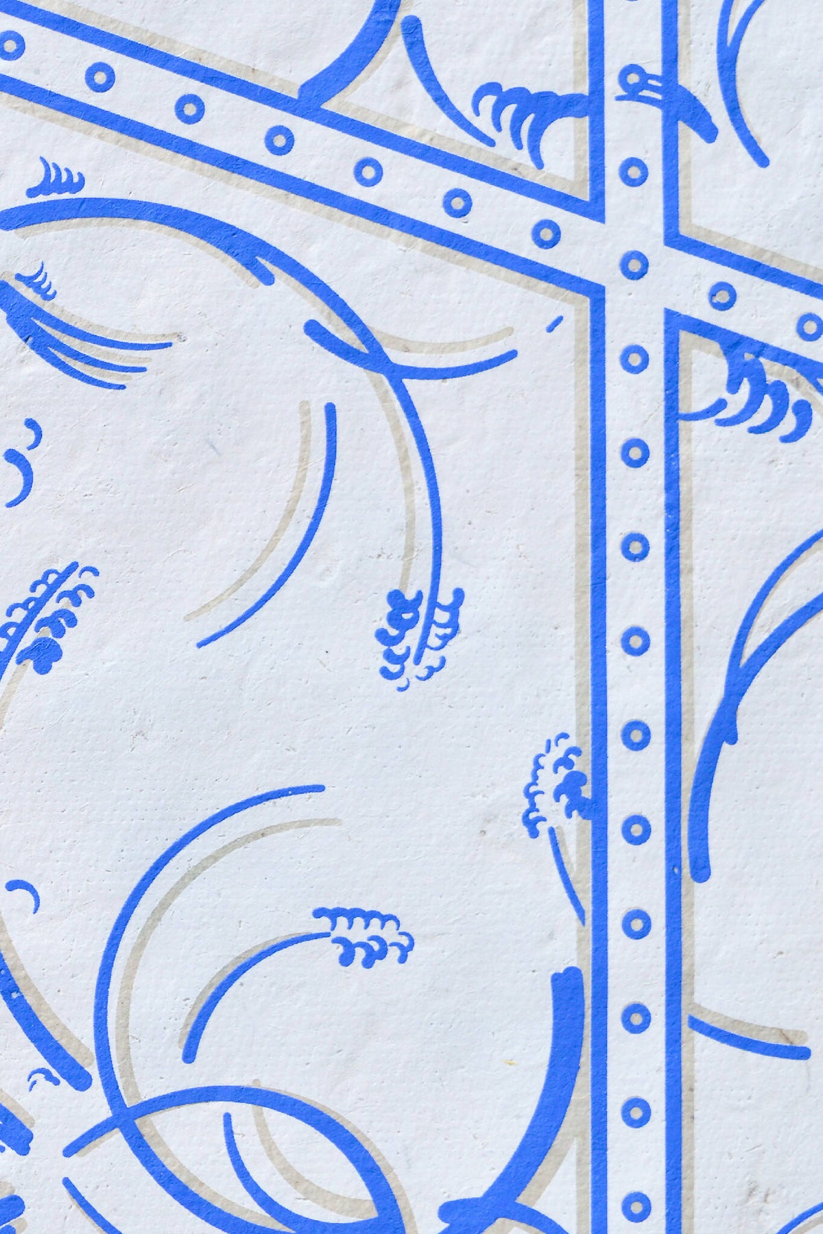 Détail de tissu bleu, arabesques courbes dans un cadre à clous