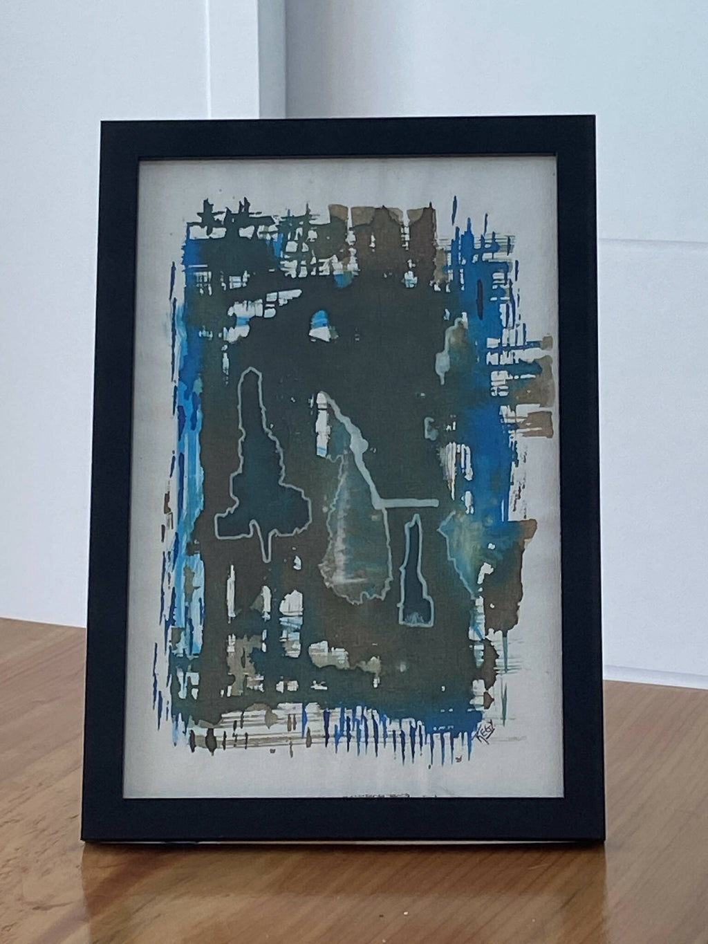 Cadre noir avec œuvre abstraite bleue et grise, motifs texturés et lignes verticales