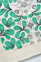 Coupon de tissu imprimé vert, motifs feuillages et fleurs stylisées, détails noirs