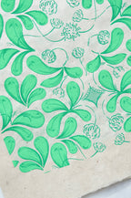Coupon de tissu imprimé vert, motif feuillagé et fleurs, fond clair
