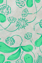 Coupon de tissu imprimé vert, gros plan sur motifs floraux et feuilles stylisées