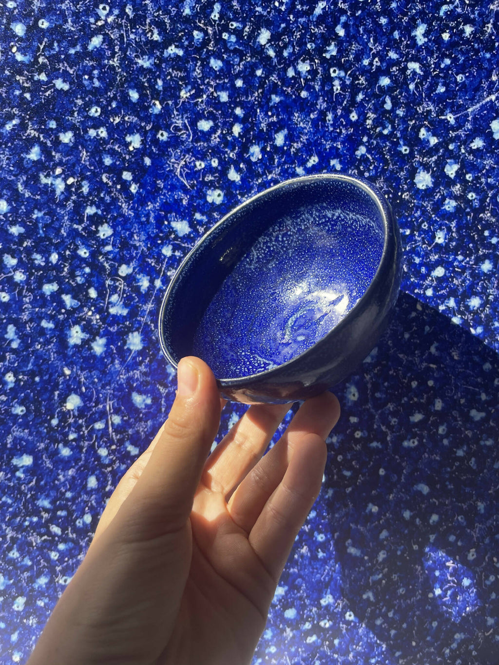 Photographie bleue scintillante, main tenant une loupe sur le motif.
