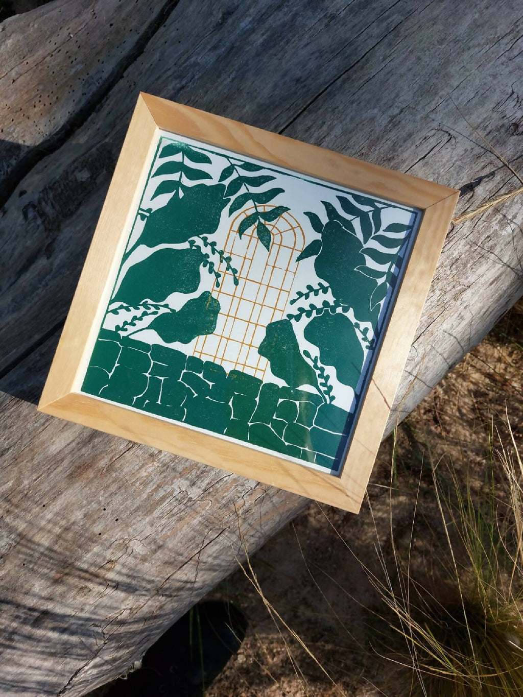 Cadre en bois avec illustration végétale verte et cage dorée sur fond crème.