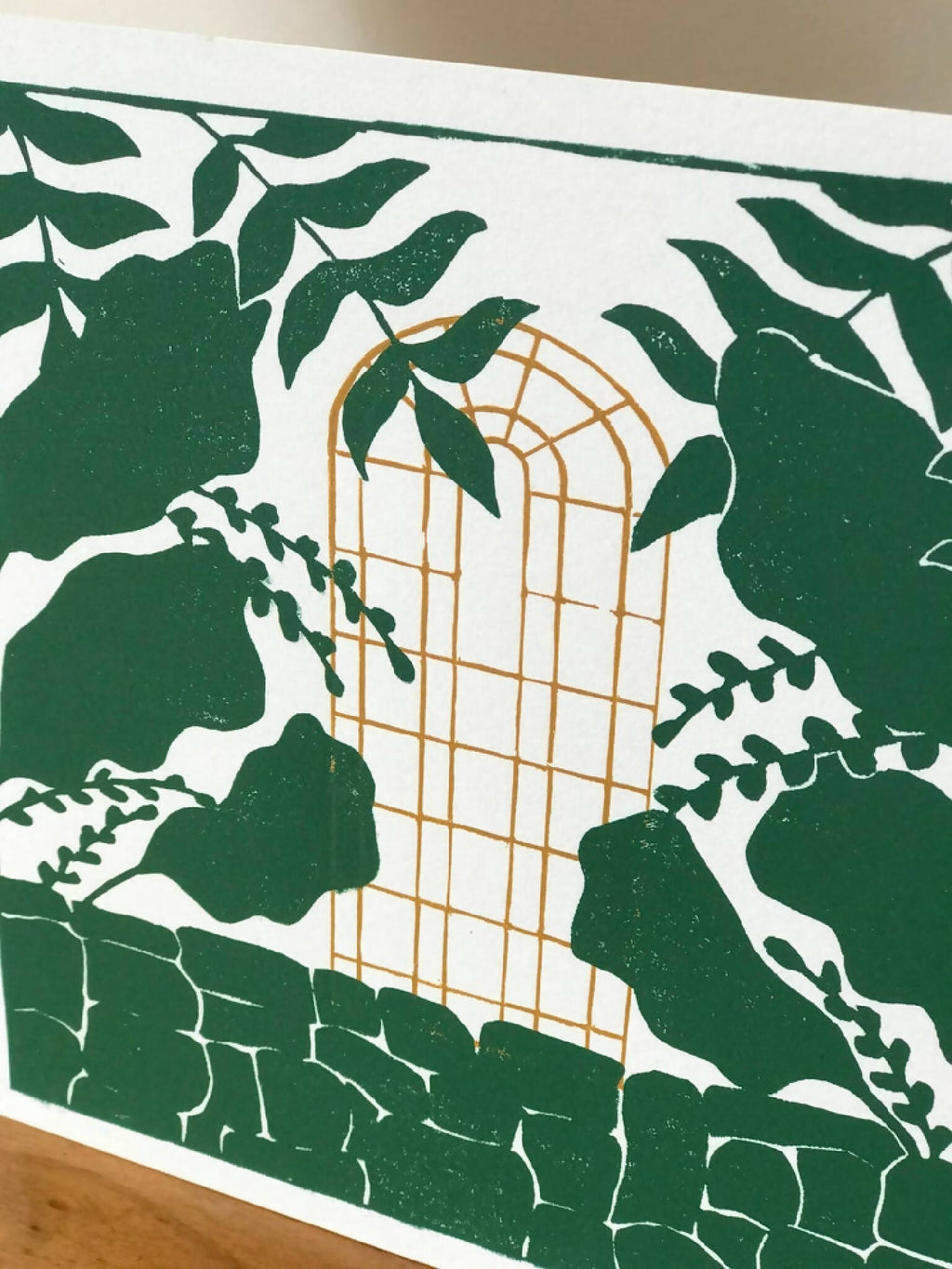 Affiche encadrée: cage dorée et feuillages verts sur fond clair avec éléments d’oiseaux.