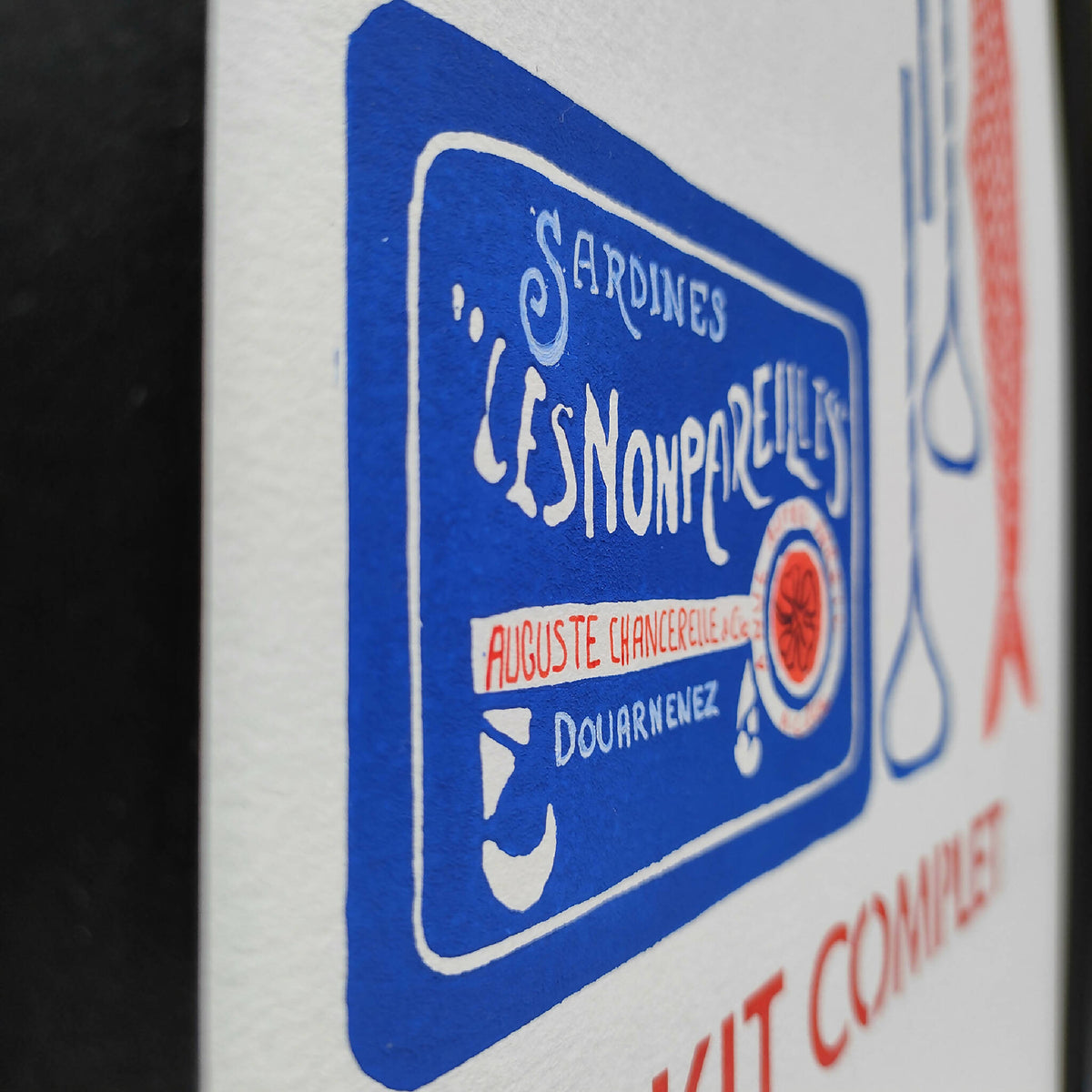 Gros plan d’un logo bleu de sardines sur affiche, avec texte et pictogramme rouge.