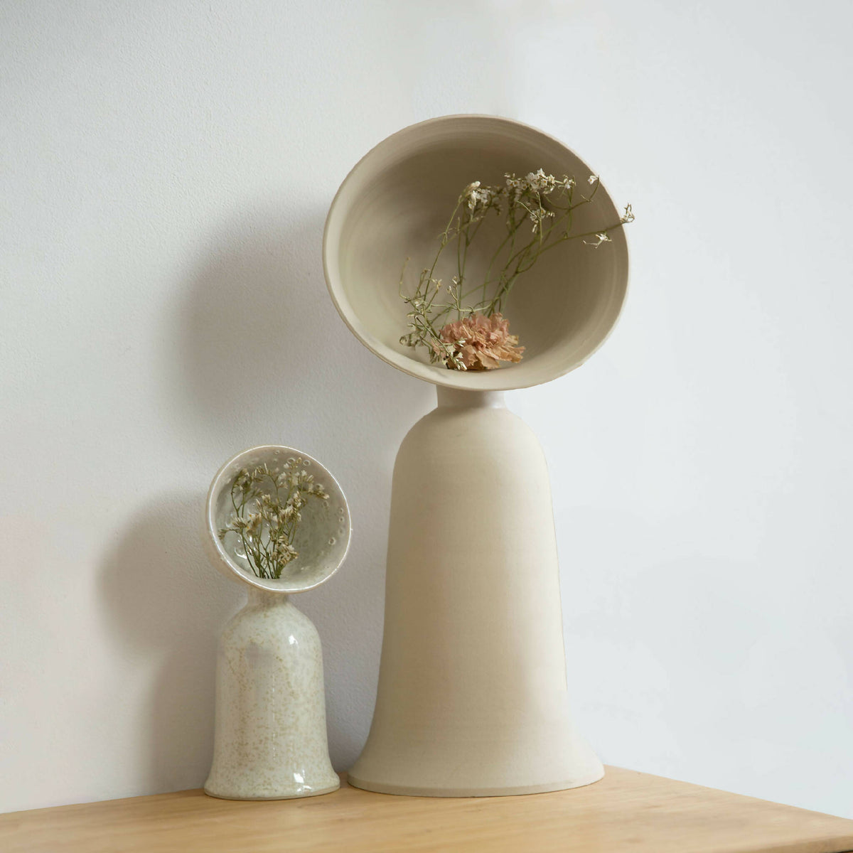 Vase soliflore beige avec bouquet de fleurs séchées, vue de face.