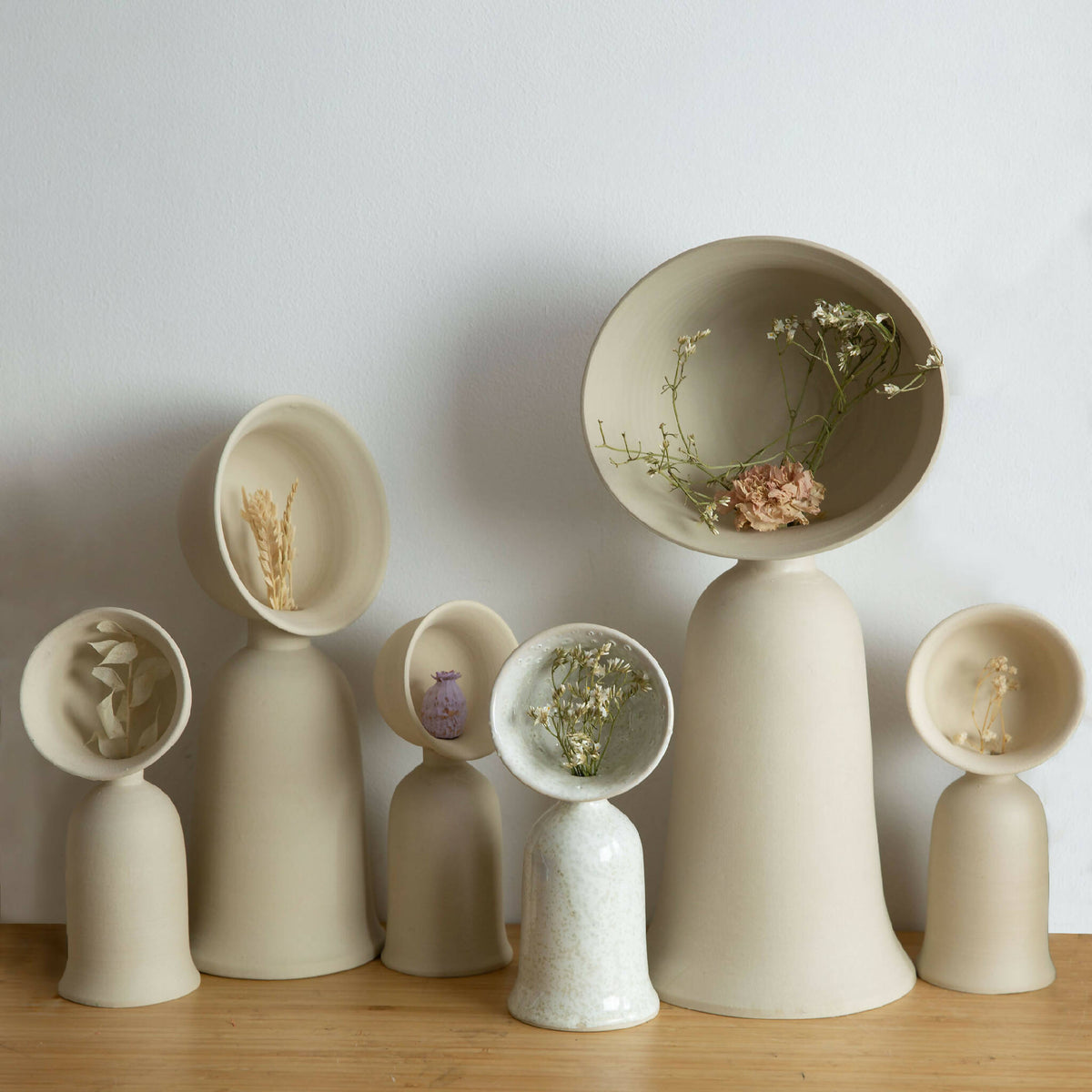 Ensemble de vases soliflores en céramique ivoire et beige, avec fleurs séchées.