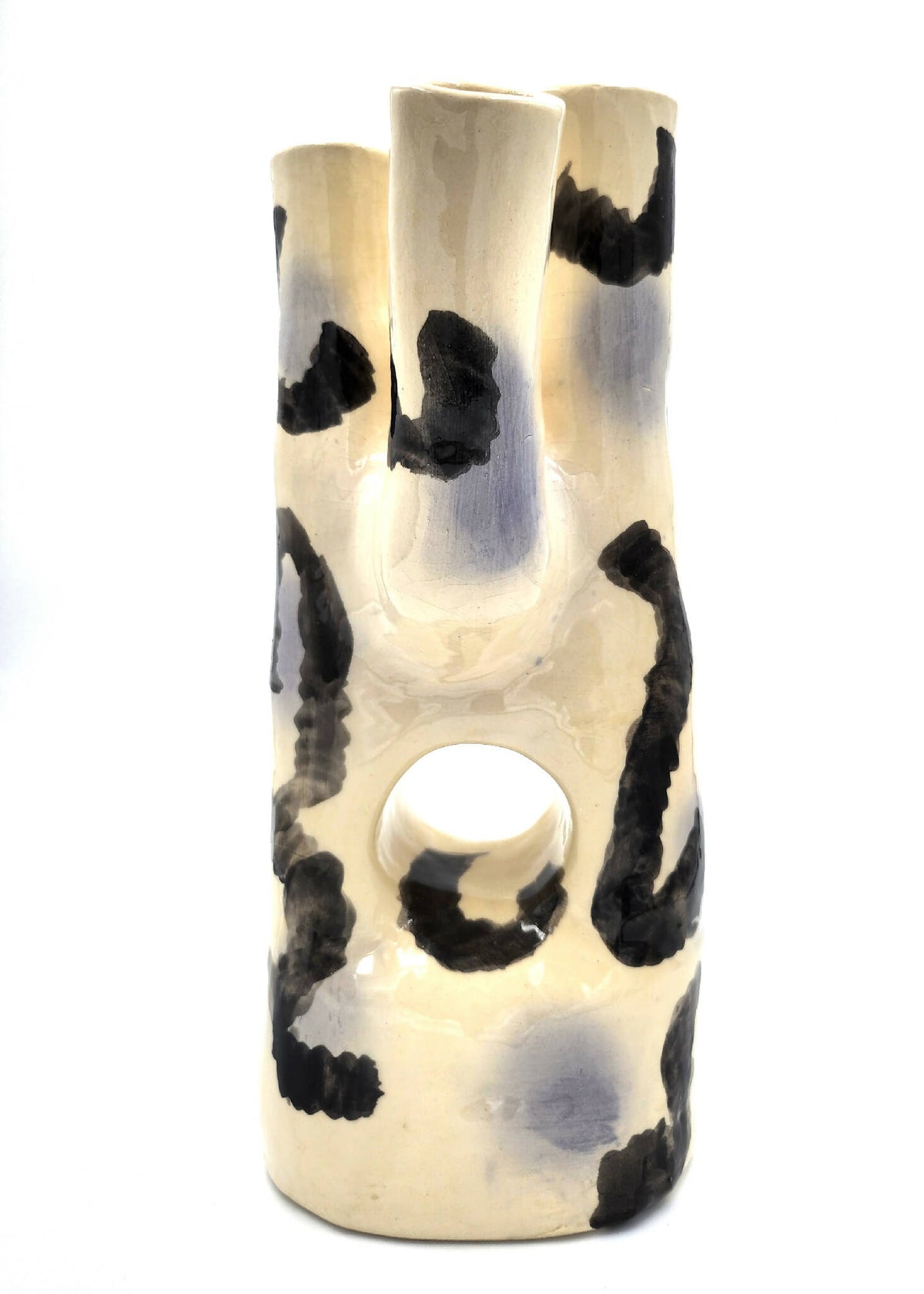 Vase en céramique crème avec motifs noirs abstraits et ouverture circulaire en haut.