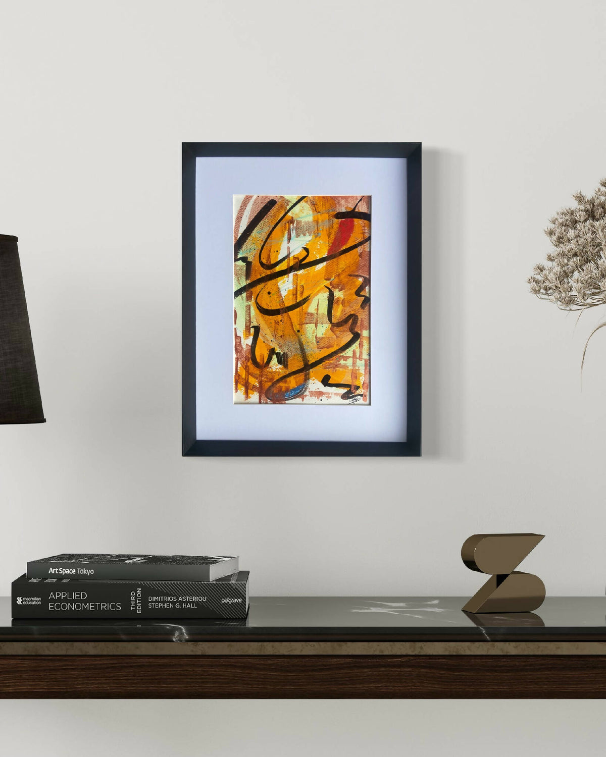 Œuvre abstraite encadrée, touches noires et orange sur fond clair, style gestuel.