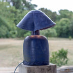 Lampe à double abat-jour bleu, vue rapprochée sur base en béton.