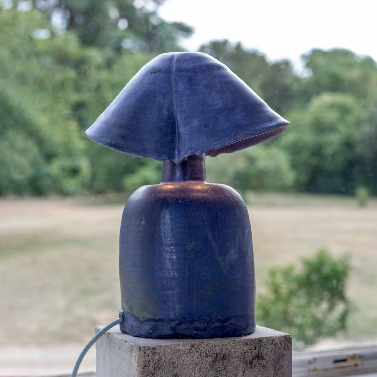 Lampe à double abat-jour bleu, vue rapprochée sur base en béton.