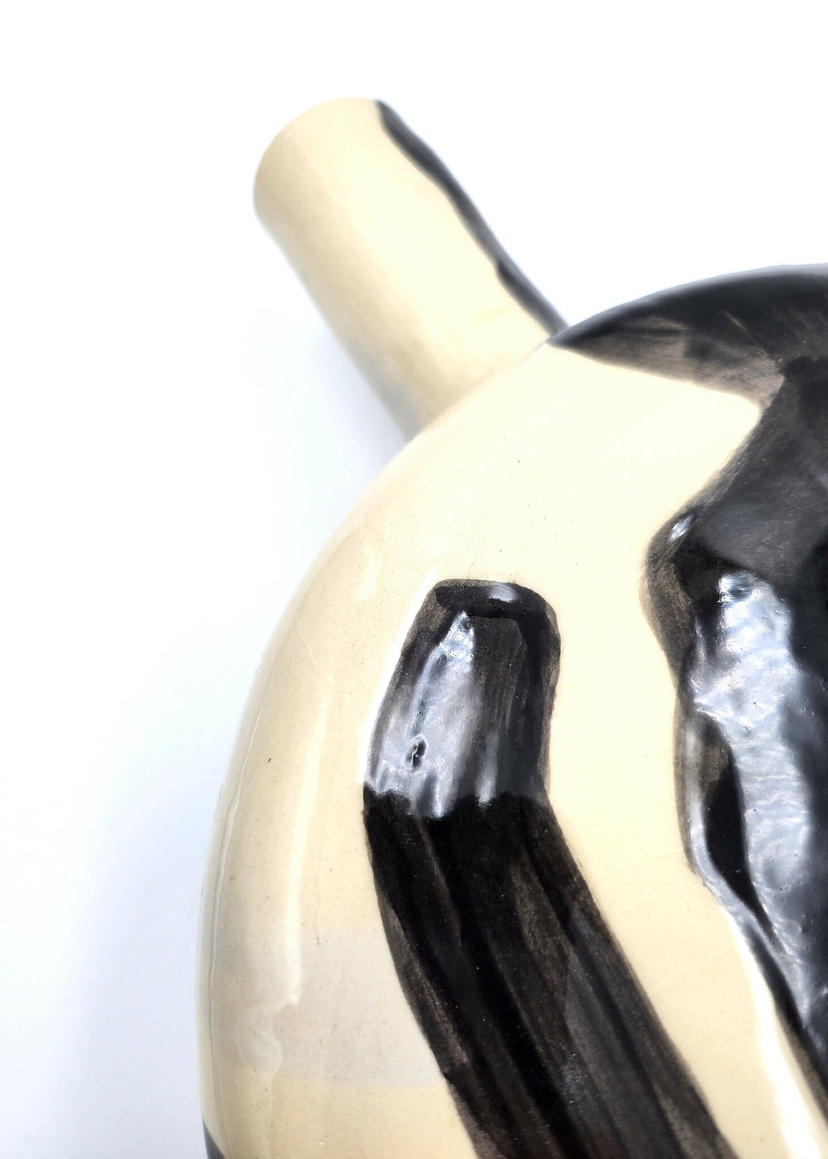 Vase crème, motif noir texturé sur la panse, gros plan du décor