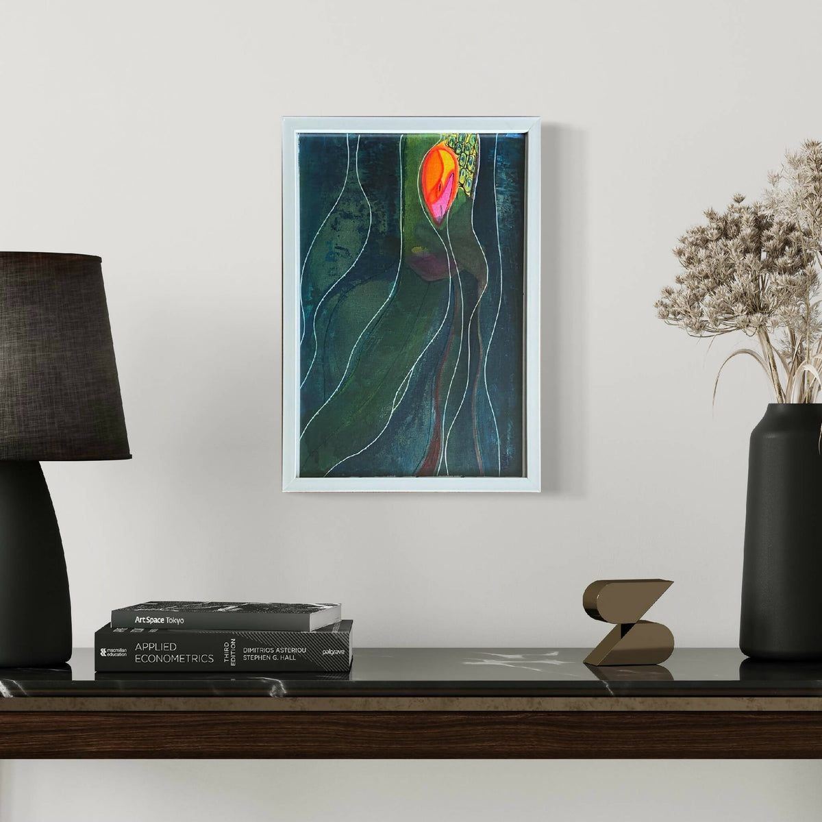Tableau abstrait encadré, formes vertes et bleues avec lignes blanches, motif coloré.