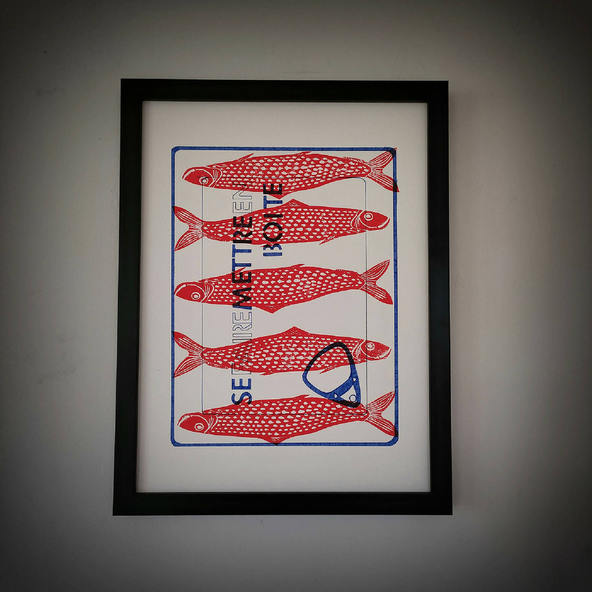 Cadre noir avec illustration de poissons rouges et motifs rouges sur fond clair